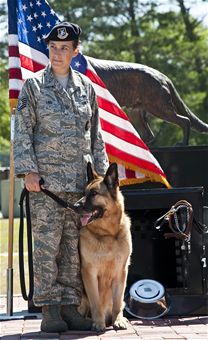 Loyal wingmen  Tech. Sgt. Rebecca Lind stands with Bak, her adopted retired military working dog, during an MWD memorial ceremony May 17, 2011, at the Air Force Armament Museum at Eglin Air Force Base, Fla. Sergeant Lind is assigned to the 1st Special Operations Security Forces Squadron at Hurlburt Field, Fla. (U.S. Air Force photo/Samuel King Jr.) 